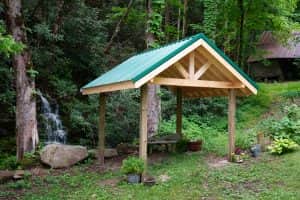 Wooden pavilion with a green roof at a waterfall wedding site in the Smoky Mountains