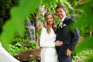 Wedding couple posing among green leaves at a waterfall in the Smoky Mountains